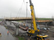 Construction de la nouvelle passerelle au-dessus de l'autoroute 40 pour permettre aux randonneurs de rejoindre les deux sections du parc-nature de la Pointe-aux-Prairies.