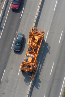 Véhicule de transfert automoteur en action lors du changement de configuration des voies de circulation.